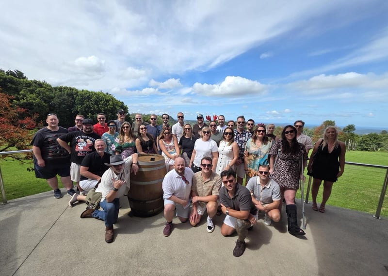 Australia team group photo on a lawn overlooking the coast