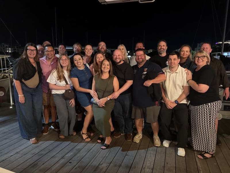 Australia team group photo on a waterfront deck at night